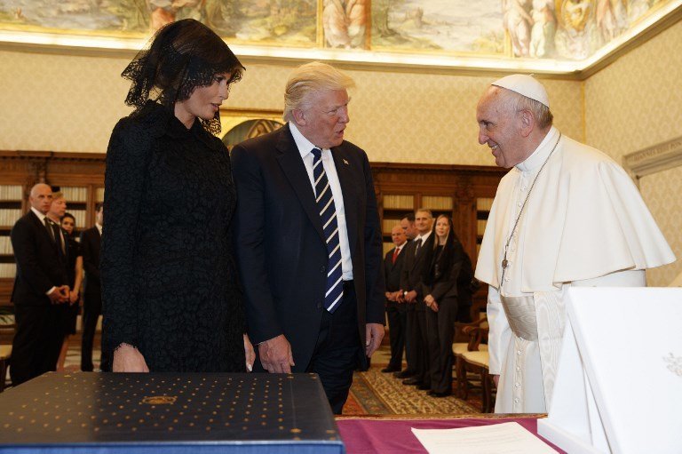 Pope Francis (R) exchanges gifts with US President Donald Trump and US First Lady Melania Trump during a private audience at the Vatican on May 24, 2017. US President Donald Trump met Pope Francis at the Vatican today in a keenly-anticipated first face-to-face encounter between two world leaders who have clashed repeatedly on several issues. / AFP PHOTO / POOL / Evan Vucci