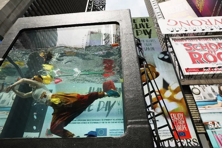 NEW YORK, NY - MAY 31: Performance artist Annie Saunders performs in Times Square in Holoscenes, a tank that rapidly fills with water and engulfs the performer, as part of the World Science Festival on May 31, 2017 in New York City. As part of the tenth World Science Festival, Holoscenes developed out of a concern that water from itensifying floods, rising seas, and longer droughts will be a central issue of the 21st century. Holoscenes is performed in a twelve ton glass aquarium and will be performed from 6pm to 11pm, June 1 - 3.   Spencer Platt/Getty Images/AFP