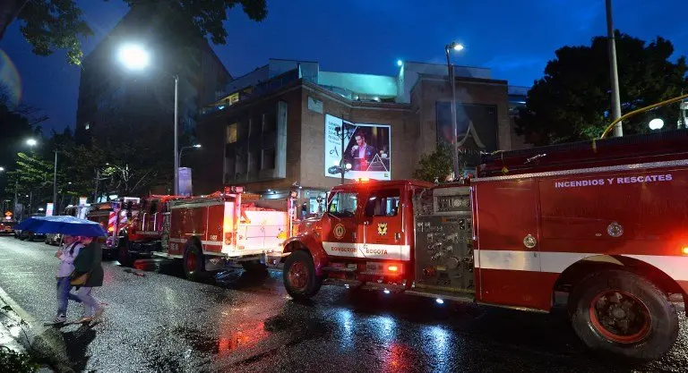 Colombian firefighters stand outside a shopping center following an explosion inside the building which -according to authorities- left one dead and eleven injured, in Bogota, Colombia, on June 17, 2017. / AFP PHOTO / Raul Arboleda