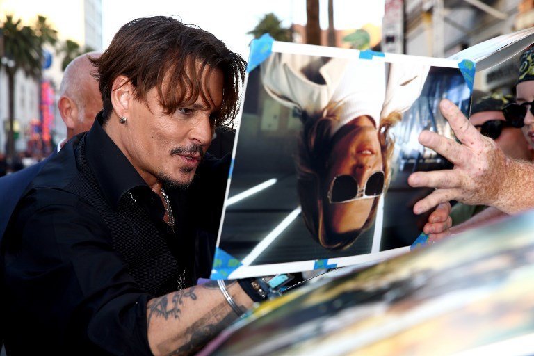 HOLLYWOOD, CA - MAY 18: Actor Johnny Depp signs autographs for fans during the premiere of Disney's "Pirates Of The Caribbean: Dead Men Tell No Tales" at Dolby Theatre on May 18, 2017 in Hollywood, California.   Rich Fury/Getty Images/AFP