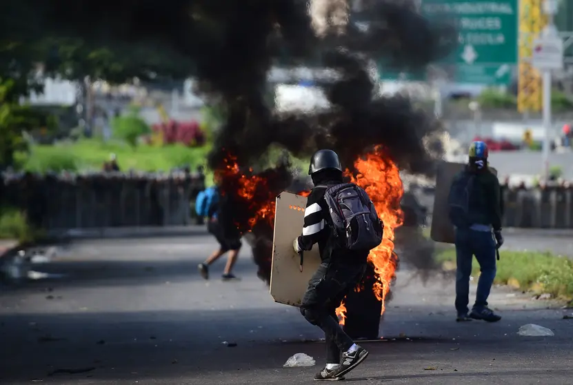 Anti-government activists clash with security forces during a protest against the elections for a Constituent Assembly proposed by Venezuelan President Nicolas Maduro, in Caracas on July 30, 2017.
Deadly violence erupted around the controversial vote, with a candidate to the all-powerful body being elected shot dead and troops firing weapons to clear protesters in Caracas and elsewhere. / AFP PHOTO / Ronaldo SCHEMIDT