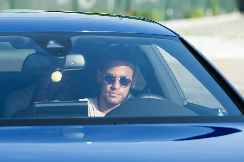 Barcelona's Brazilian forward Neymar drives into the parkinglot to takes part in a training session at the Sports Center FC Barcelona Joan Gamper in Sant Joan Despi, near Barcelona on August 2, 2017 following rumour that Neymar is considering a move to French club PSG for which the club would have to shell out some 222 million euros, enough to trigger the 25-year-old's transfer release clause. / AFP PHOTO / Josep LAGO