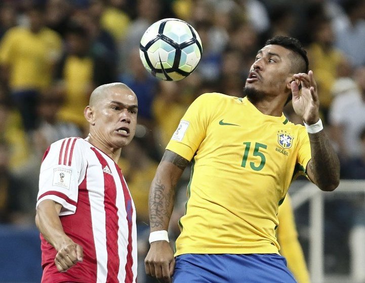 Brazil's midfieler Paulinho (R) and Paraguay's defender Dario Veron jump for the ball during their 2018 FIFA World Cup qualifier football match in Sao Paulo, Brazil on March 28, 2017. / AFP PHOTO / Miguel SCHINCARIOL