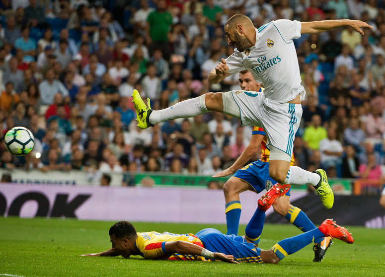 Real Madrid's French forward Karim Benzem (R) kicks the ball during the Spanish league football match Real Madrid CF vs Valencia CF at the Santiago Bernabeu stadium in Madrid on August 27, 2017. / AFP PHOTO / CURTO DE LA TORRE