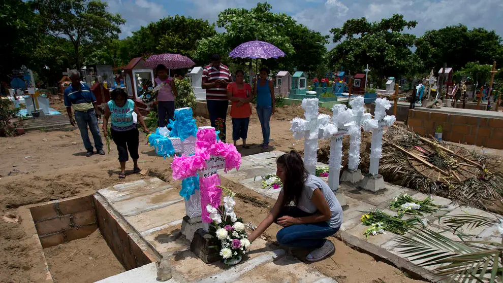 En esta imagen del 2 de julio de 2017, tías, tíos y abuelos colocan flores y cruces caseras de concreto sobre las tumbas de los niños Martínez, su madre y su padre en un cementerio del estado de Coatzacoalcos, México. Las autoridades creen que la familia de seis miembros fue asesinada porque el violento cártel de los Zetas sospechaba que el padre, taxista desempleado, había jugado un papel en un ataque de una banda rival en la que murió un miembro de los Zetas. (AP Foto/Rebecca Blackwell)