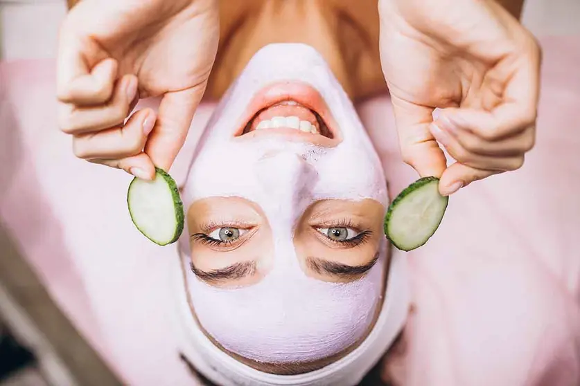 Woman with mask and cucumber on her eyes