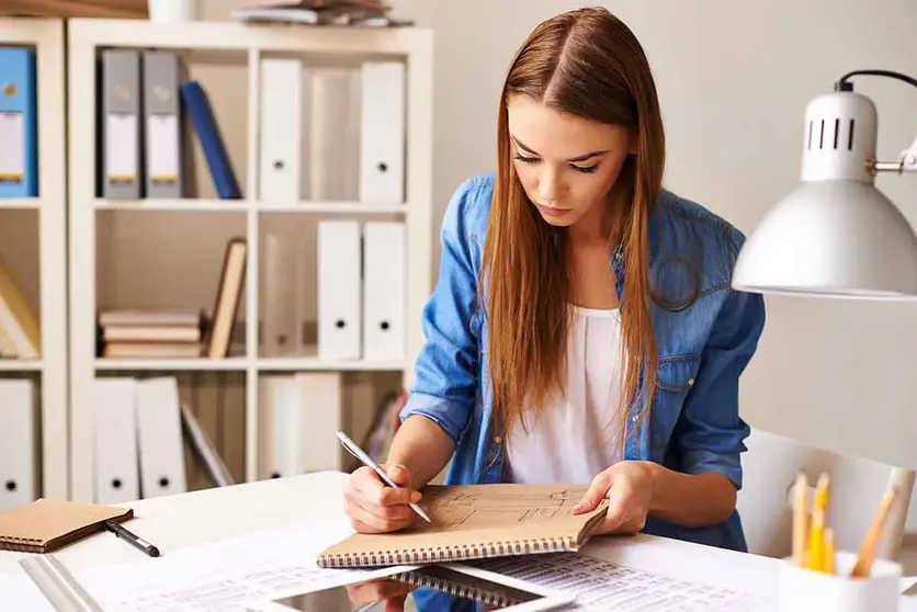 Portrait of pretty student making sketch at lesson