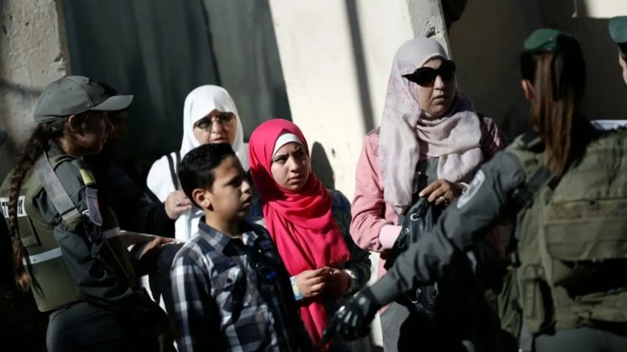 <p>Una familia palestina trata de cruzar por el punto de control militar israel&iacute; entre la ciudad cisjordana de Bel&eacute;n y Jerusal&eacute;n este viernes 10 de junio</p>