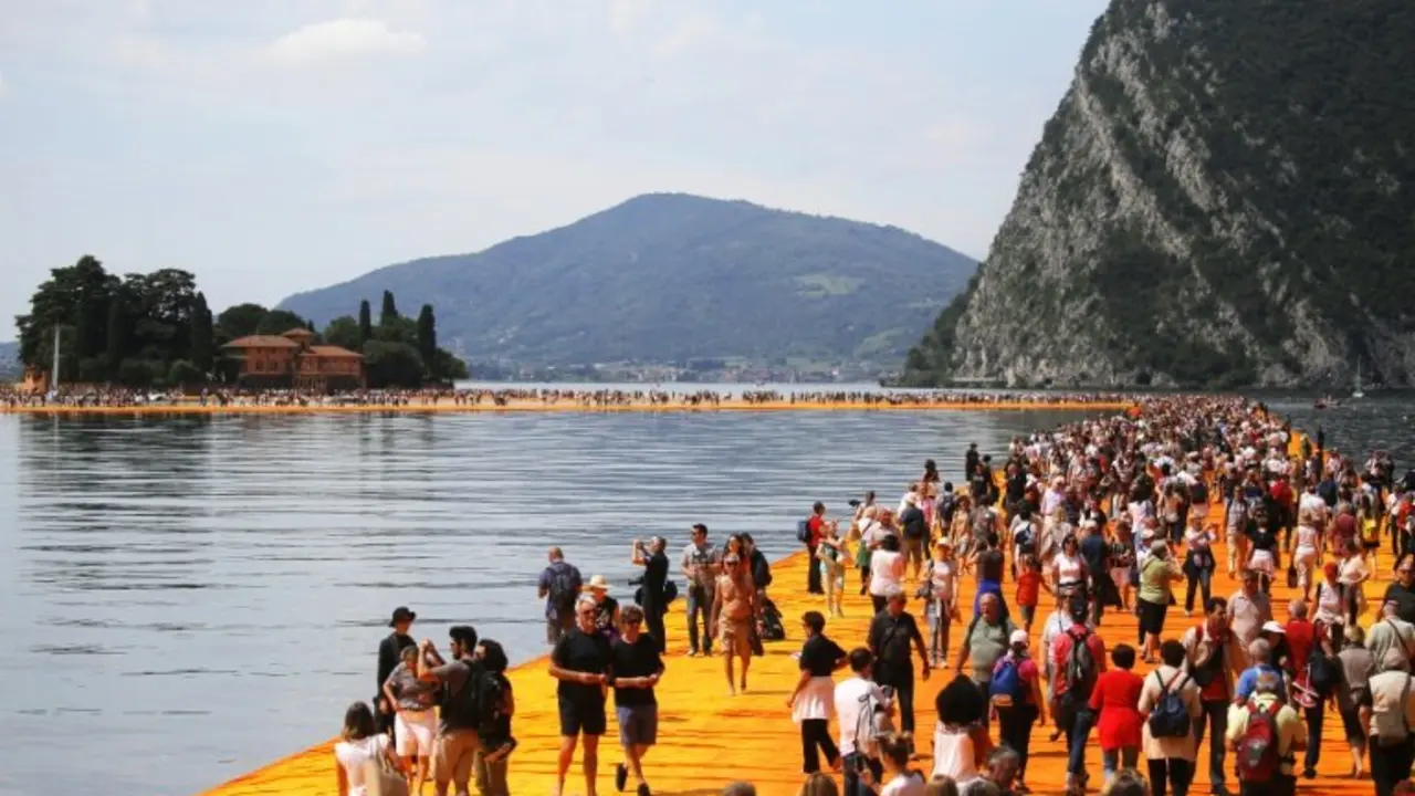 <p>Decenas de personas caminan sobre la instalaci&oacute;n del artista Christo Vladimirov el 18 de junio de 2016 sobre el lago Iseo en el norte de Italia</p>