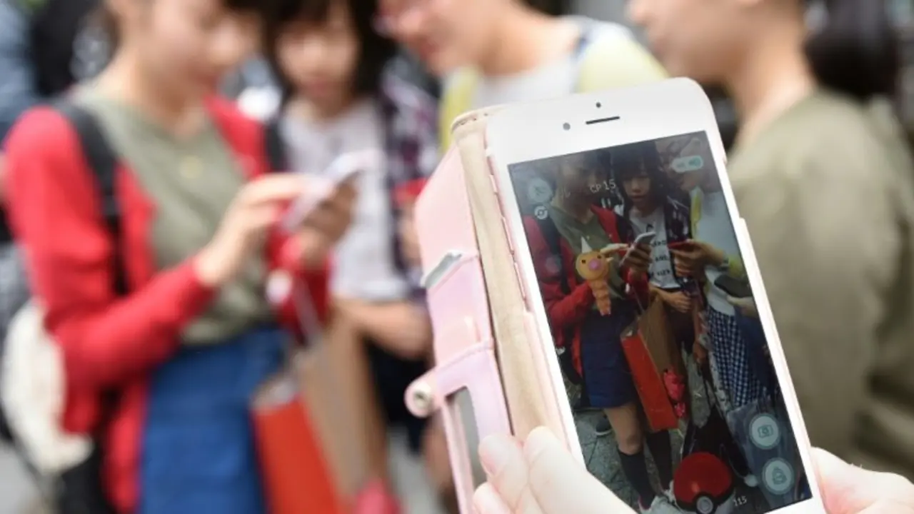 <p>Estudiantes japoneses juegan a Pok&eacute;mon Go en su tel&eacute;fonos m&oacute;viles, el 22 de julio de 2016 en Tokio</p>