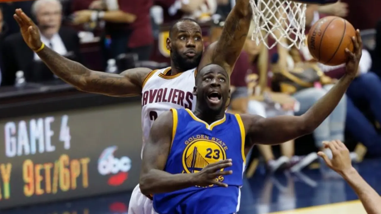 <p>Draymond Green (D), de Golden State Warriors, penetra ante la marca de LeBron James (I), de Cleveland Cavaliers, en el tercer partido de la final de la NBA disputado Cleveland, Ohio, el 8 de junio de 2016</p>