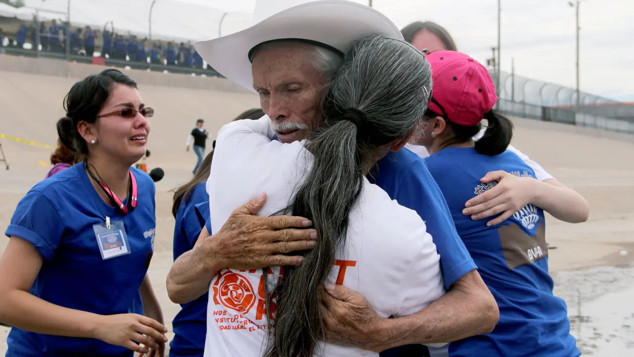Mexicans hug each other during an event called "Hugs, No Walls" in front of the border fence separating Mexico from the US, in Ciudad Juarez, Chihuahua State, Mexico on August 10, 2016. 
For two minutes there were no walls for 250 families of undocumented immigrants in the United States who joined in an embrace with their siblings, parents and children from different parts of Mexico, in the center of the Rio Bravo. / AFP PHOTO / HERIKA MARTINEZ
