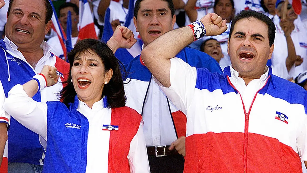 Antonio Saca (R) and Ana Vilma de Escobar presidential and vice-presidential candidates for the Alianza Republicana Nacionalista (ARENA) sing their party's anthem during a closing campaing rally at the Jorge "El Magico" Gonzalez stadium in San Salvador March 14, 2004. Presidential elections will be held on March 21st.       AFP PHOTO/Roberto ESCOBAR / AFP PHOTO / ROBERTO ESCOBAR