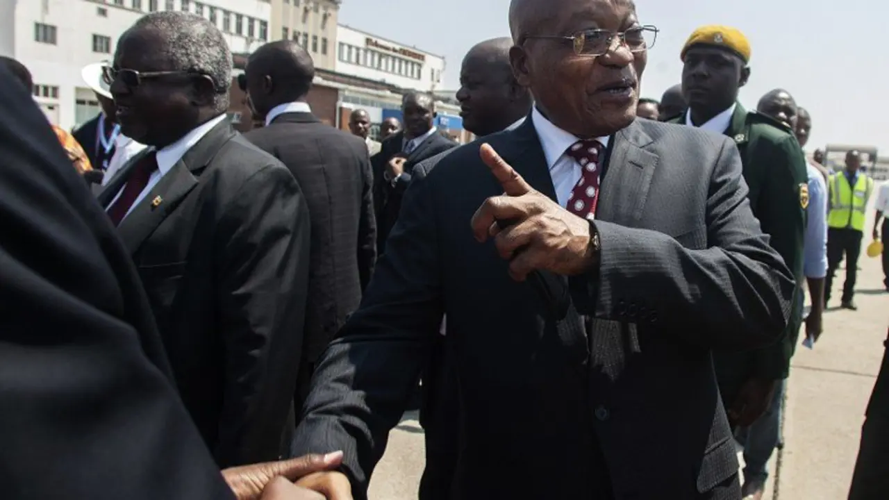 South African president Jacob Zuma (R) is greeted upon his arrival for an official state visit at the Harare International Airport on November 3, 2016 in Harare. 
South African President Jacob Zuma on November 3 faced increasing calls to resign after a damaging probe unearthed further evidence of alleged corruption at the top of the ANC government. The country's anti-graft watchdog ordered a judicial inquiry into possible criminal activity in Zuma's relationship with the Guptas, a wealthy Indian family accused of wielding undue political influence.  / AFP PHOTO / JEKESAI NJIKIZANA