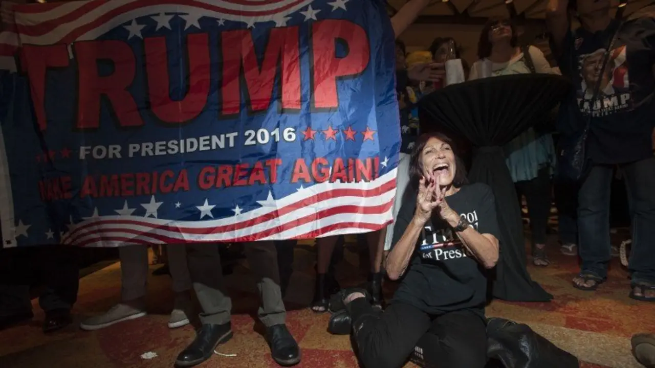Supporter of Republican candidate Donald Trump, Robin Labani, 50, of Gilbert, Arizona cheers as election results come in during a viewing party at a hotel in downtown Phoenix, Arizona on November 8, 2016.
Millions of Americans voted November 8th for their new leader in a historic election that will either elevate Democrat Hillary Clinton as their first woman president or hand power to maverick populist Donald Trump. / AFP PHOTO / Laura Segall
