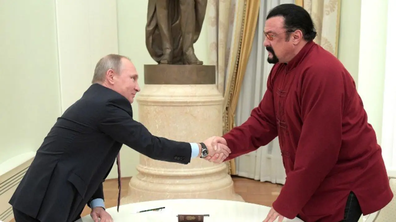 Russian President Vladimir Putin (L) shakes hands with US action hero actor Steven Seagal after presenting a Russian passport to him during a meeting at the Kremlin in Moscow on November 25, 2016. / AFP PHOTO / SPUTNIK / Alexey DRUZHININ