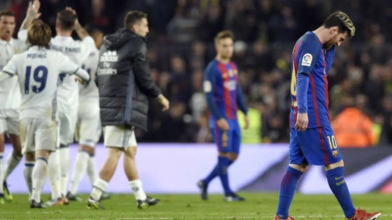 Barcelona's Argentinian forward Lionel Messi (R) walks on the pitch as Real Madrid players celebrate during the Spanish league football match FC Barcelona vs Real Madrid CF at the Camp Nou stadium in Barcelona on December 3, 2016. / AFP PHOTO / LLUIS GENE