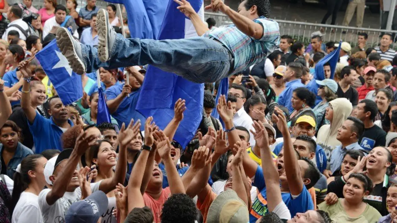 Supporters of Honduran President Juan Orlando Hernandez celebrate in Tegucigalpa, on December 14, 2016. 
The Supreme Electoral tribunal (TSE) authorized Hernandez to present his candidacy to the reelection. / AFP PHOTO / ORLANDO SIERRA