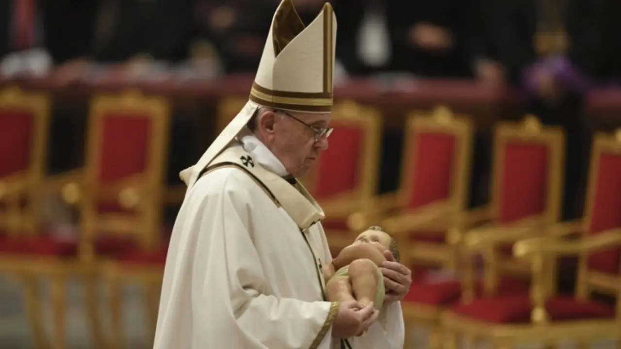 Pope Francis carries the statue of baby Jesus during a mass on Christmas eve marking the birth of Jesus Christ on December 24, 2016 at St Peter's basilica in Vatican / AFP PHOTO / ANDREAS SOLARO