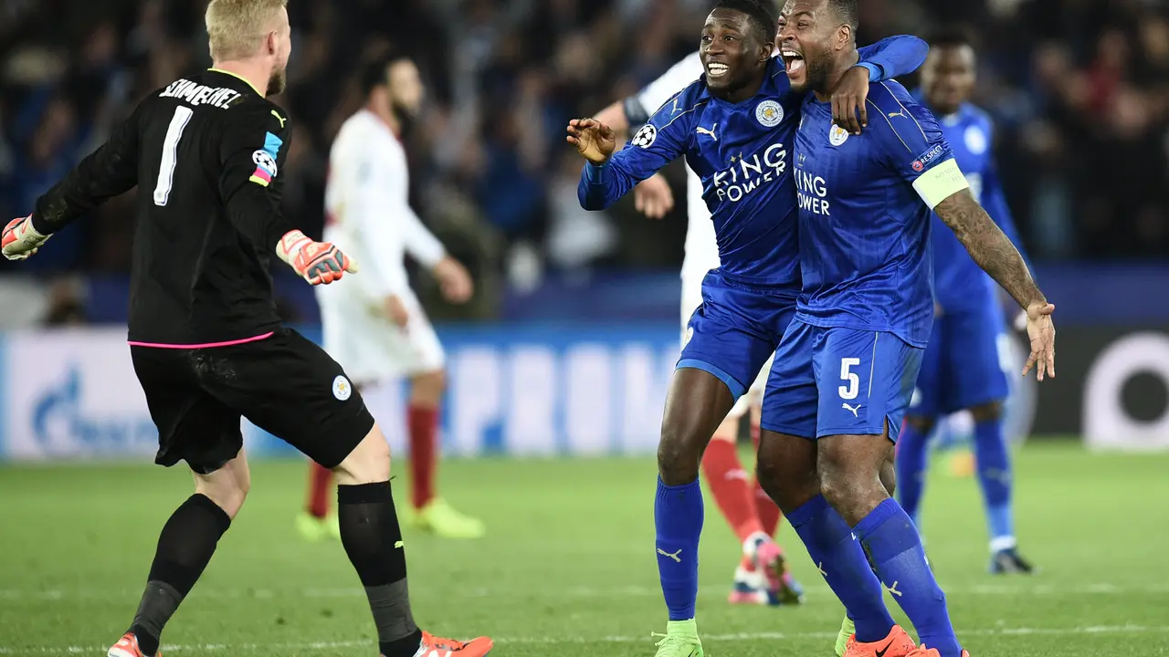Leicester City's Nigerian midfielder Wilfred Ndidi (C), Leicester City's English-born Jamaican defender Wes Morgan (R) and Leicester City's Danish goalkeeper Kasper Schmeichel (L) celebrate their victory at the final whistle during the UEFA Champions League round of 16 second leg football match between Leicester City and Sevilla at the King Power Stadium on March 14, 2017. / AFP PHOTO / Oli SCARFF