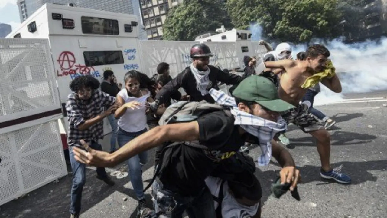 Venezuelan opposition activists clash with the police during a protest against the government of President Nicolas Maduro on April 6, 2017 in Caracas.
Violence erupted for a third straight day at protests against the government, escalating tension over moves to keep the leftist leader in power. / AFP PHOTO / JUAN BARRETO