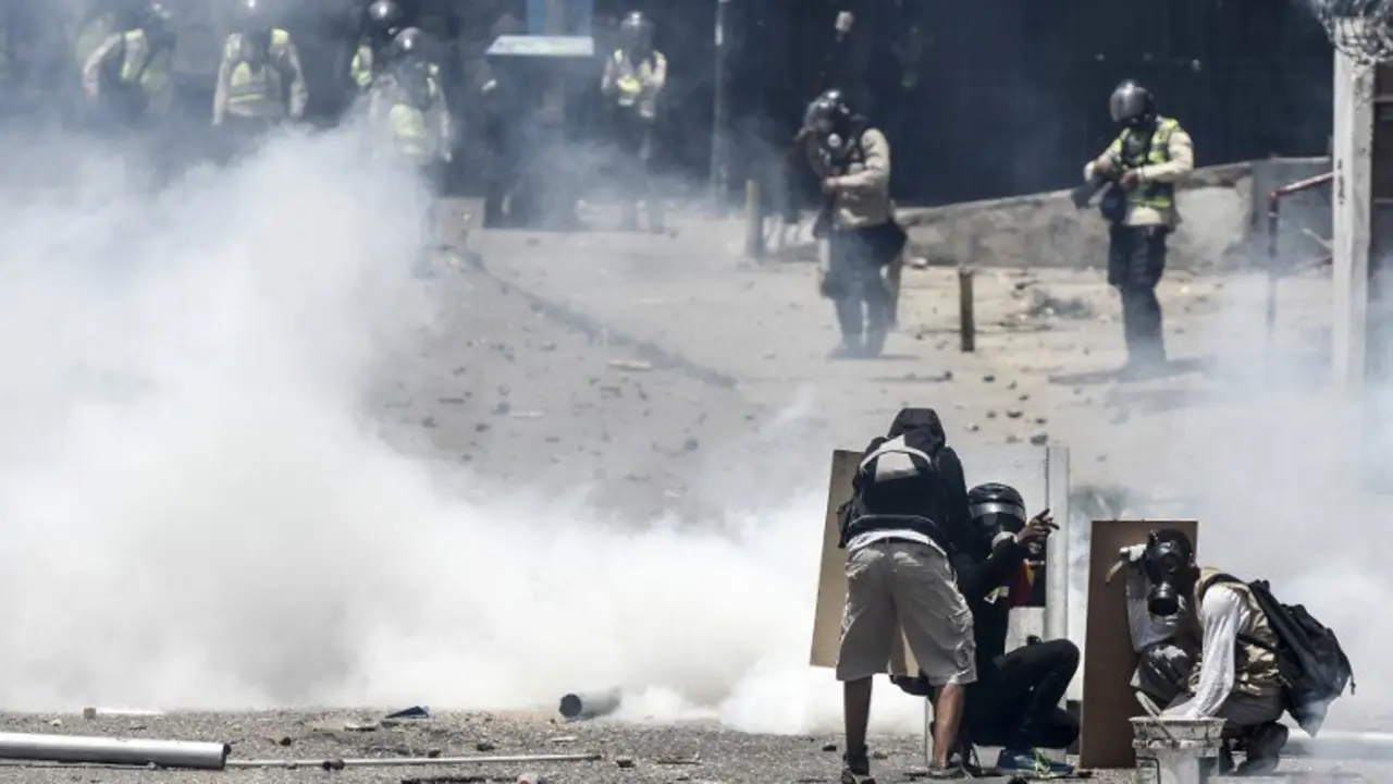 Demonstrators clash with the police during a rally against Venezuelan President Nicolas Maduro, in Caracas on April 19, 2017. 
Venezuela braced for rival demonstrations Wednesday for and against President Nicolas Maduro, whose push to tighten his grip on power has triggered waves of deadly unrest that have escalated the country's political and economic crisis. / AFP PHOTO / JUAN BARRETO