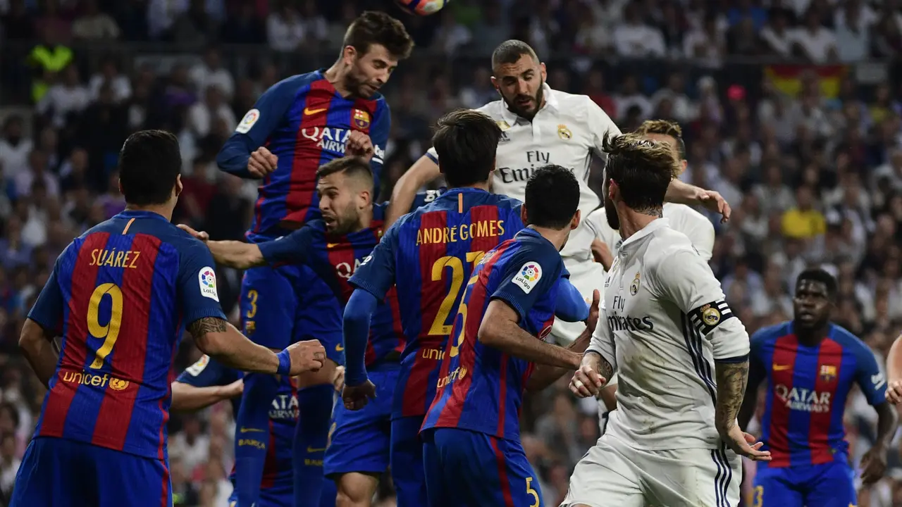 Barcelona's defender Gerard Pique (top L) heads the ball with Real Madrid's French forward Karim Benzema (top R) during the Spanish league football match Real Madrid CF vs FC Barcelona at the Santiago Bernabeu stadium in Madrid on April 23, 2017. / AFP PHOTO / PIERRE-PHILIPPE MARCOU