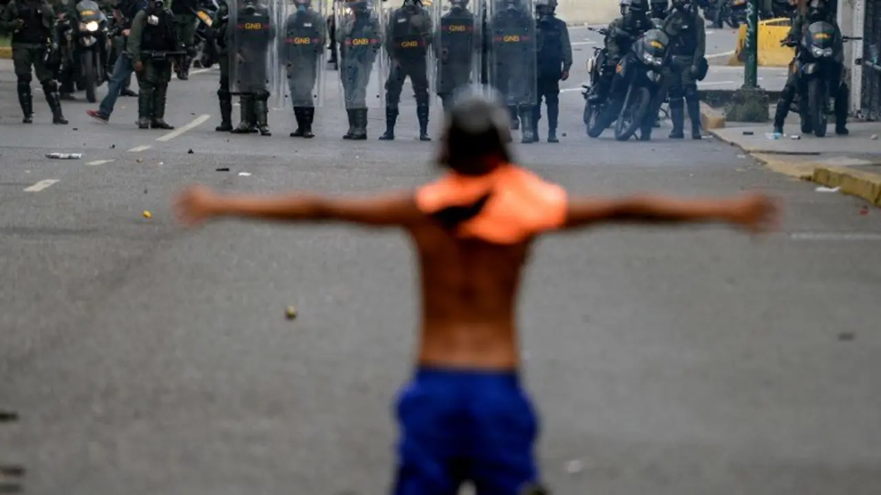 Opposition activists clash with riot police during a protest against President Nicolas Maduro in Caracas on April 26, 2017. 
Venezuelan riot police fired tear gas to stop anti-government protesters from marching on central Caracas, the latest clash in a wave of unrest that, up to now, has left 26 people dead. / AFP PHOTO / FEDERICO PARRA