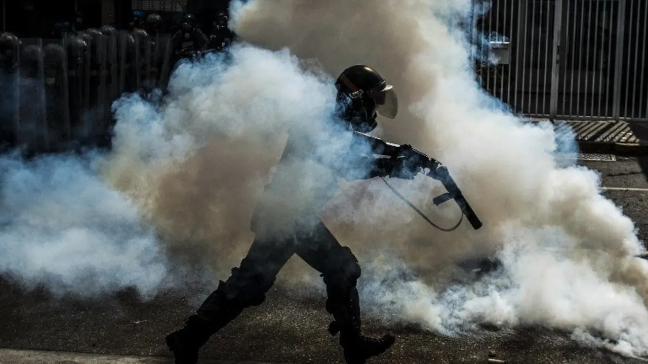 A member of the National Guard cracks down on opposition demonstrators during a march against President Nicolas Maduro, in Caracas on April 26, 2017.
Venezuelan riot police fired tear gas to stop anti-government protesters from marching on central Caracas, the latest clash in a wave of unrest that, up to now, has left 26 people dead. / AFP PHOTO / CARLOS BECERRA