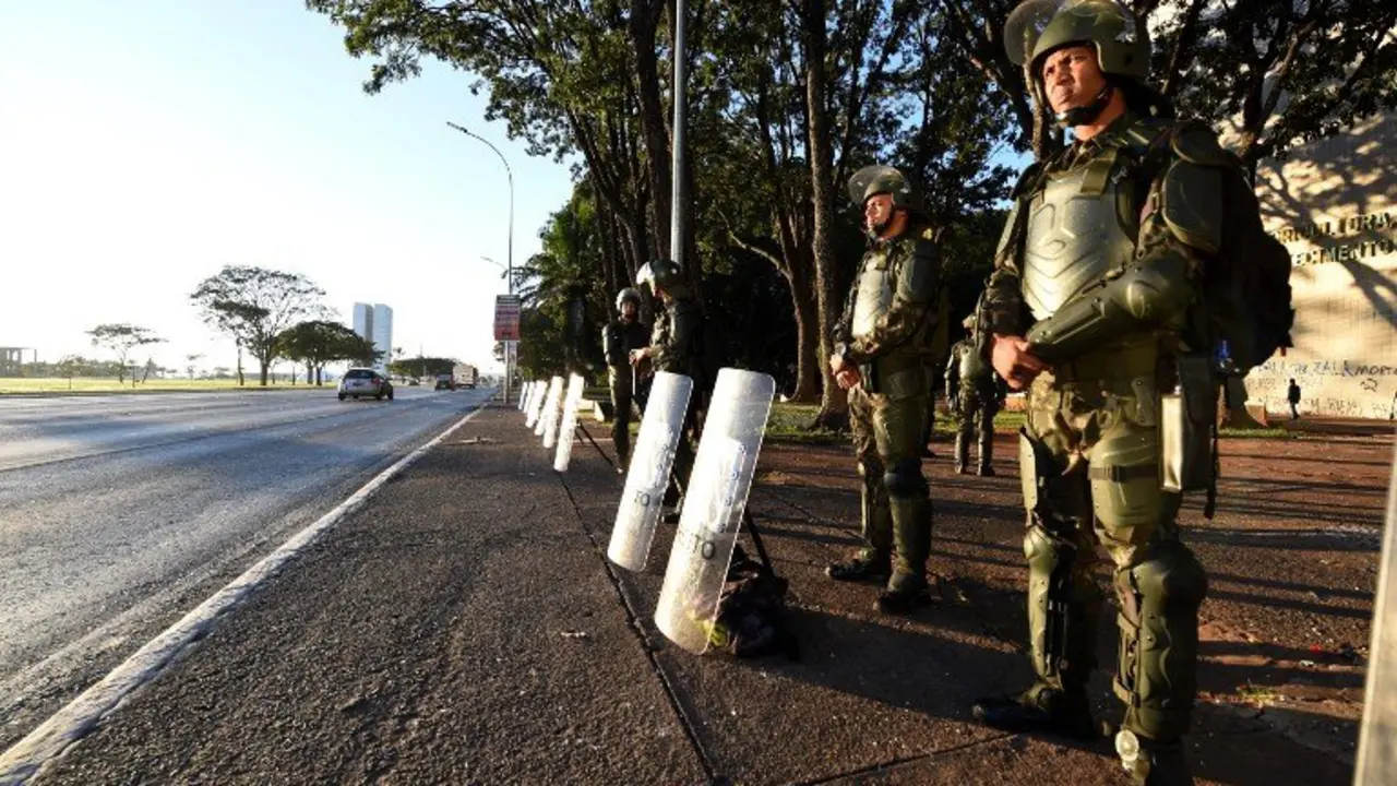 Brazilian Army military police personnel in riot gear guard public buildings in Brasilia, on May 25, 2017.
Brazilian soldiers deployed Wednesday to defend government buildings in the capital Brasilia after protesters demanding the exit of President Michel Temer smashed their way into ministries and fought with riot police. / AFP PHOTO / EVARISTO SA