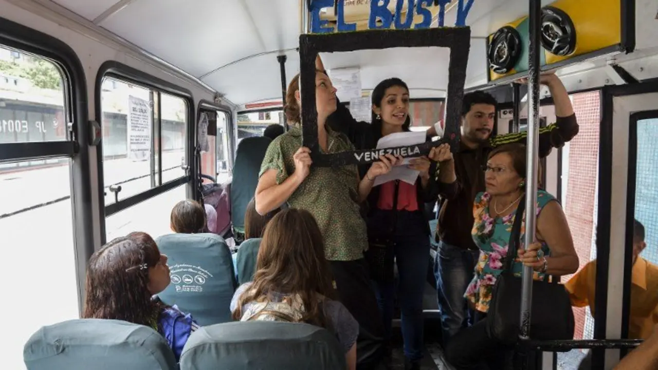 Laura Castillo (L), Maria Gabriela Fernandez (C) and Dereck Blanco (R) give a presentation of the Bus TV news in Caracas, Venezuela, on June 6, 2017.
A group of young Venezuelan reporters board buses to present the news, as part of a project to keep people informed in the face of what the opposition and the national journalists' union describe as censorship by the government of Nicolas Maduro. / AFP PHOTO / LUIS ROBAYO