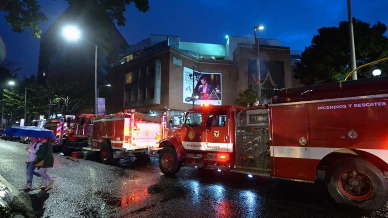 Colombian firefighters stand outside a shopping center following an explosion inside the building which -according to authorities- left one dead and eleven injured, in Bogota, Colombia, on June 17, 2017. / AFP PHOTO / Raul Arboleda