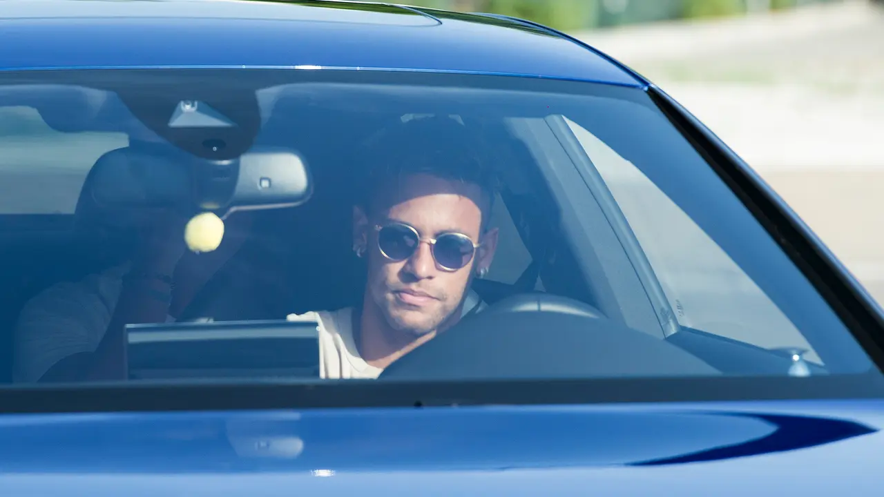 Barcelona's Brazilian forward Neymar drives into the parkinglot to takes part in a training session at the Sports Center FC Barcelona Joan Gamper in Sant Joan Despi, near Barcelona on August 2, 2017 following rumour that Neymar is considering a move to French club PSG for which the club would have to shell out some 222 million euros, enough to trigger the 25-year-old's transfer release clause. / AFP PHOTO / Josep LAGO