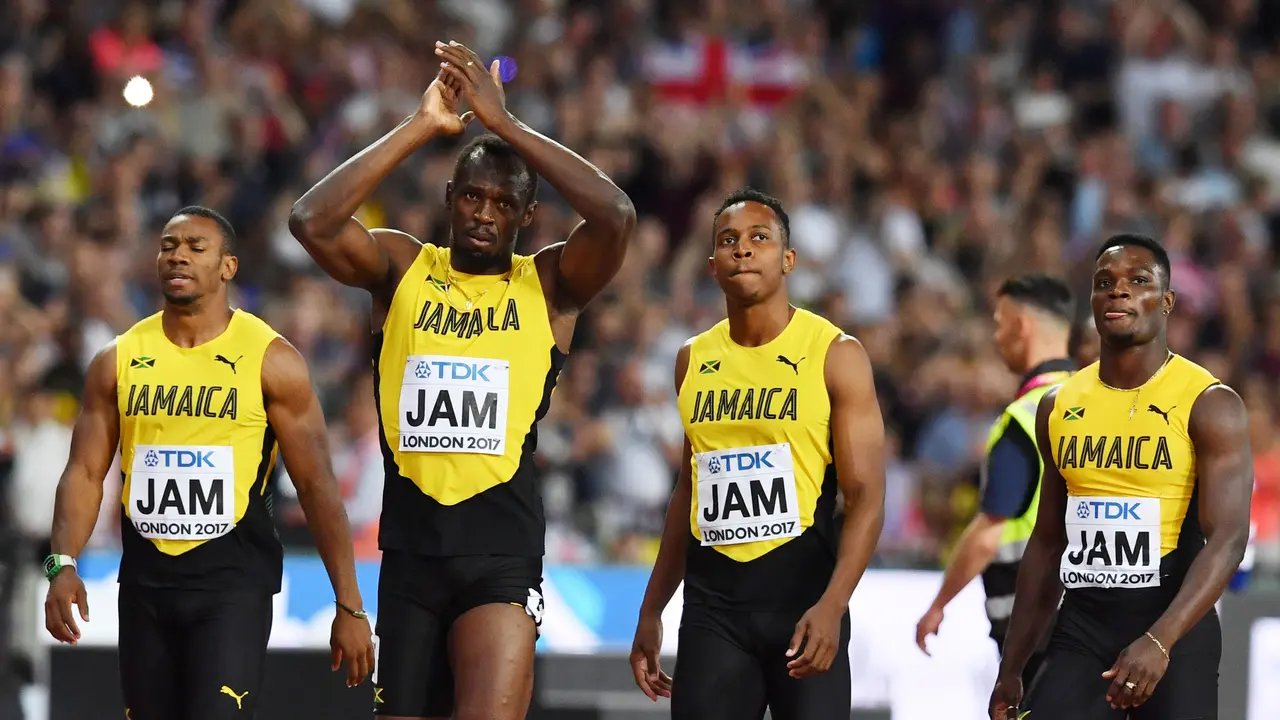 Jamaica's Julian Forte (2R), Yohan Blake (L) and Omar McLeod (R) walk with Jamaica's Usain Bolt (2L) after Bolt pulled up injured in the final of the men's 4x100m relay athletics event at the 2017 IAAF World Championships at the London Stadium in London on August 12, 2017. / AFP PHOTO / Ben STANSALL