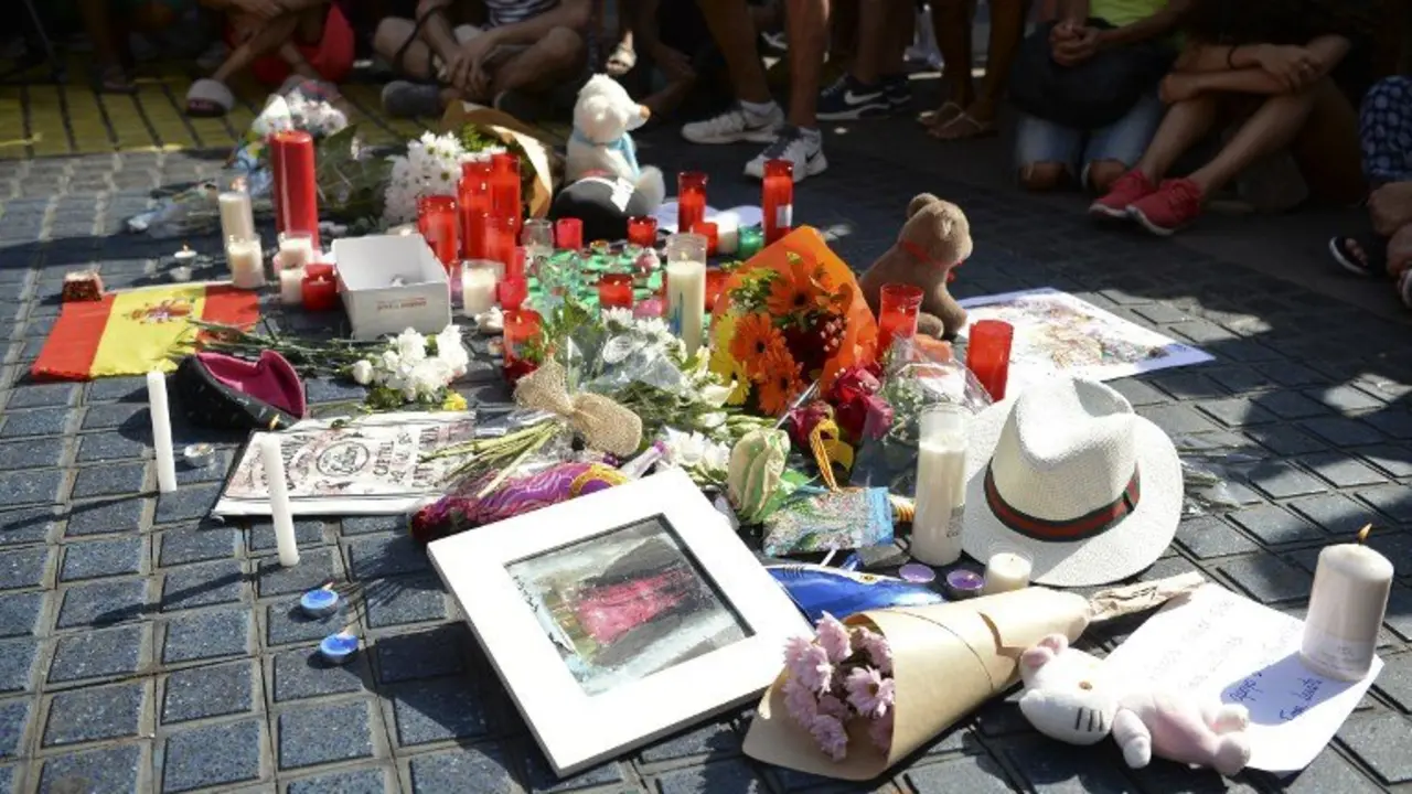 People sit next to flowers, messages, stuffed toys and others items displayed on the Rambla boulevard on August 18, 2017, to pay tribute to the victims of the Barcelona attack, a day after a van ploughed into the crowd, killing 13 persons and injuring over 100 on the Rambla in Barcelona.
Drivers have ploughed on August 17, 2017 into pedestrians in two quick-succession, separate attacks in Barcelona and another popular Spanish seaside city, leaving 13 people dead and injuring more than 100 others. In the first incident, which was claimed by the Islamic State group, a white van sped into a street packed full of tourists in central Barcelona on Thursday afternoon, knocking people out of the way and killing 13 in a scene of chaos and horror. Some eight hours later in Cambrils, a city 120 kilometres south of Barcelona, an Audi A3 car rammed into pedestrians, injuring six civilians -- one of them critical -- and a police officer, authorities said. / AFP PHOTO / Josep LAGO