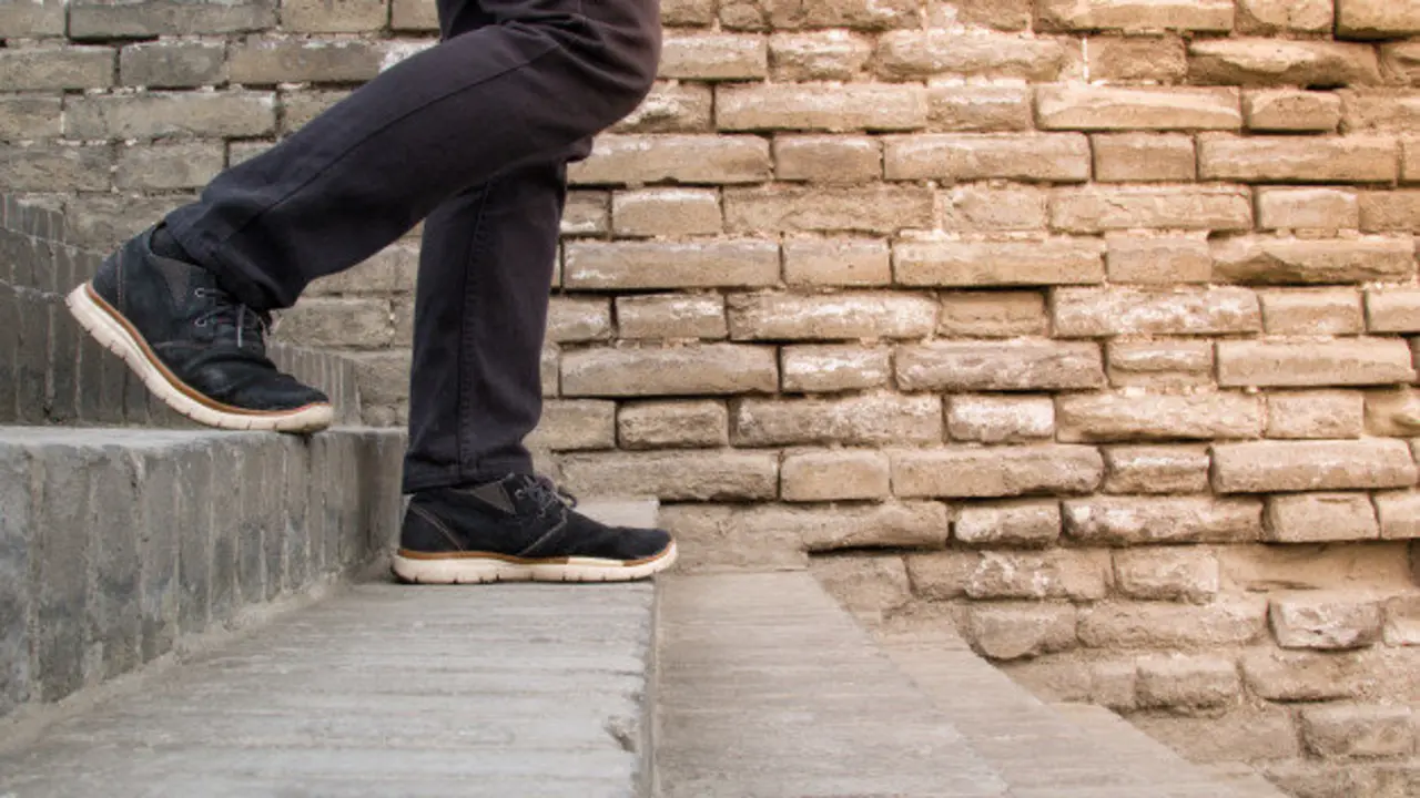 primer-plano-de-las-piernas-del-hombre-caminando-por-una-escalera-de-piedra-al-aire-libre_41991-8