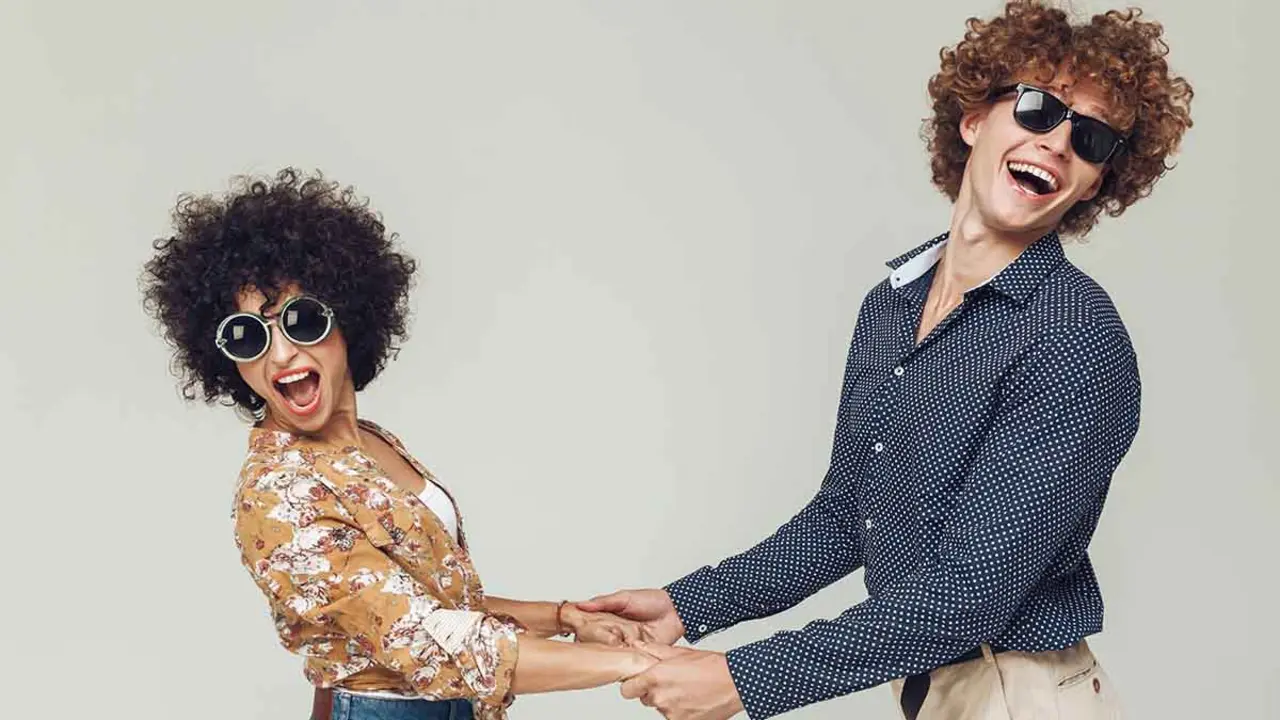 Picture of young emotional happy retro loving couple standing and posing isolated. Looking camera dancing.