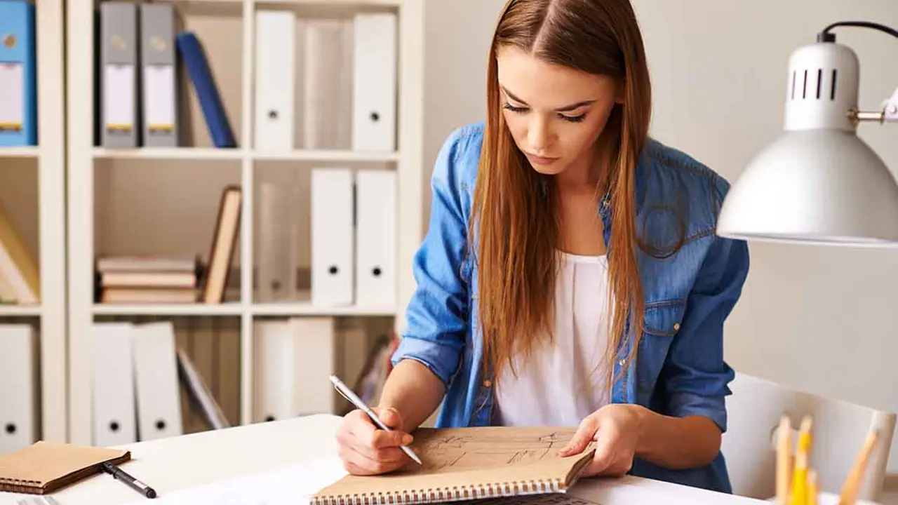 Portrait of pretty student making sketch at lesson