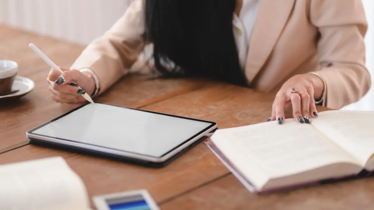 photo-of-woman-using-tablet-while-holding-book-3803224