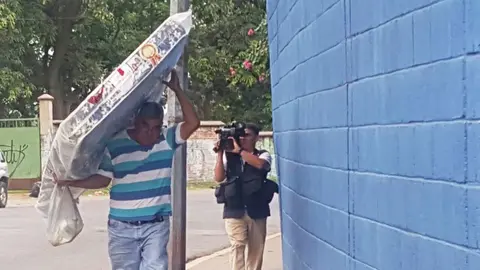 Motorista ingresa un colchón.