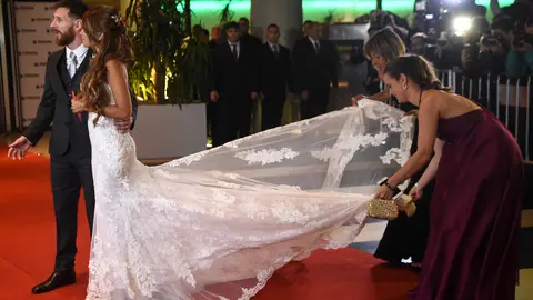 Familiares arreglan el vestido de la novia previo a posar para las cámaras.