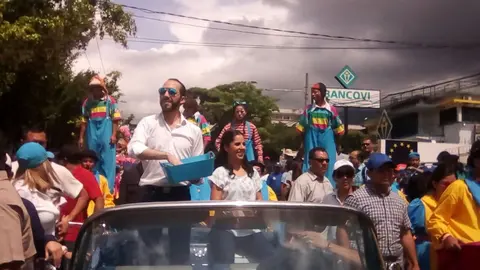 El alcalde Nayib Bukele repartiendo golosinas durante el recorrido.