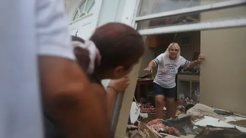 Donna Raney es ayudada para evacuar su apartamento, que resultó destruido.