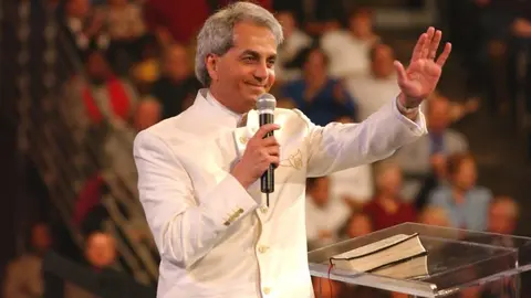 Benny Hinn es uno de los religiosos más polémicos de Estados Unidos, país en el que ha sido investigado por manipulación de impuestos, y es que las autoridades dudan del origen del patrimonio que tiene y que se estima ronda los $42 millones. Solo en Beverly Hills tiene una mansión de $10 millones.