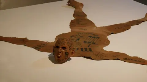 Los pandilleros aparecen como si fueran animales cazados cuya piel adorna el piso.