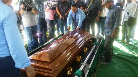 Momentos en que empleados de la funeraria La Auxiliadora bajan el féretro de los restos de la periodista en la sepultura donde morarán sus restos mortales.