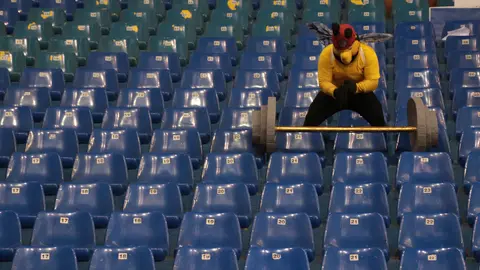 La mascota de la barra del centro penal de San Miguel trata de levantar una pesa en el Gimnasio "Adolfo Pineda" durante la inauguración de los primeros Juegos Penitenciarios de El Salvador, donde participan alrededor de 15 centros penales.