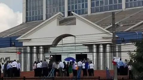 Personas desalojan el Banco Central de Reserva ubicado sobre la alameda Juan Pablo II.