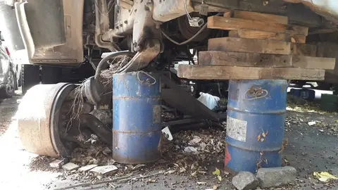 La base delantera de un camión fue colocada sobre dos barriles y trozos de madera, el peligro para que alguien se accidente es latente.