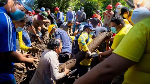 Un habitante de la comunidad ayuda a la remoción de escombros. Foto de El Salvador Times.
